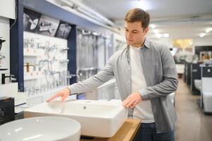 Man at the building market looking for sink into their bathroom photo