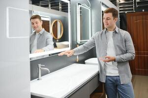 Man choosing a batgh sink with sales person photo