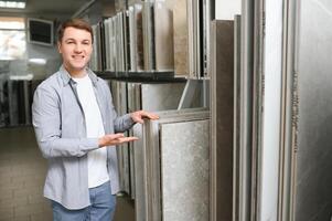 Male customer choosing kitchen ceramic tile in store photo