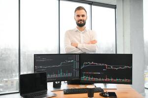 financiero analistas y día comerciantes trabajando en un ordenadores con multimonitor estaciones de trabajo con tiempo real cepo, materias primas y intercambiar mercado cartas foto