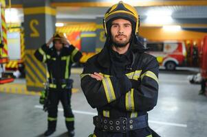 grupo de bomberos a el emergencia vehículo en el fuego estación foto