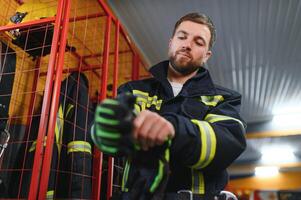 joven hermoso bombero en el fuego Departamento foto