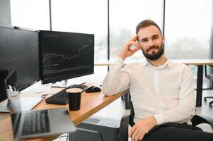 Crypto trader sits at his workplace in front of a monitor with charts. photo