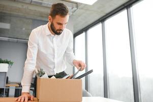 Man by dismissal. Guy lost job. Fired manager in company. Dismissal box in hands of employee. photo