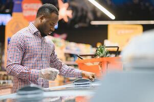 africano americano hombre compras en comida Tienda foto