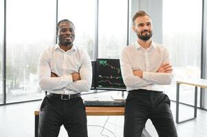Two diverse crypto traders brokers stock exchange market investors discussing trading charts research reports growth using pc computer looking at screen analyzing invest strategy, financial risks photo