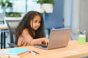 africano americano niña estudiando a ordenador portátil. en línea aprendizaje foto