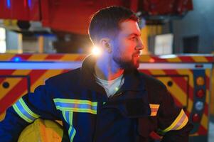 Photo of fireman with gas mask and helmet near fire engine