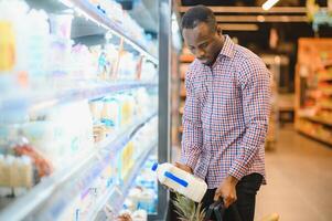 atractivo africano americano hombre compras en un supermercado foto