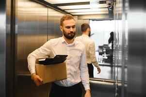 Man by dismissal. Guy lost job. Fired manager in company. Dismissal box in hands of employee. photo