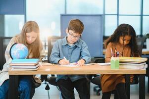 students to schoolwork during lesson in light classroom at school photo