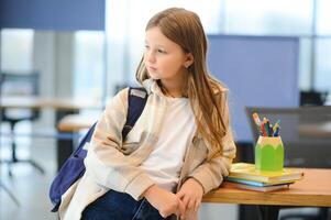 linda pequeño Chica de escuela en salón de clases foto