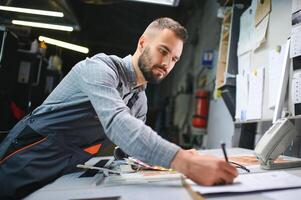 Graphic engineer or worker checking imprint quality in modern print shop photo