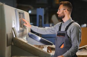 Man working in printing house with paper and paints photo