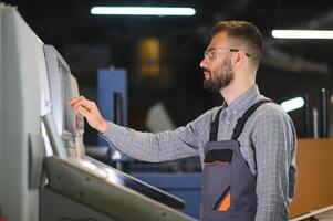 Man working in printing house with paper and paints photo