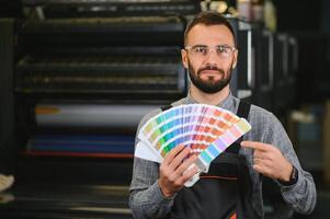 tipógrafo en pie con color muestras a el impresión fabricación foto