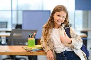 Confident smiling schoolgirl pupil student, standing at school photo