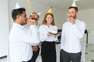 negocio equipo celebrando un cumpleaños de colega en el moderno oficina. foto