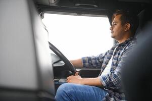 Portrait of a young handsome Indian truck driver. The concept of logistics and freight transportation. photo