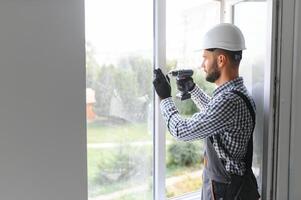 Construction worker installing window in house. photo