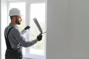 Construction worker installing window in house photo