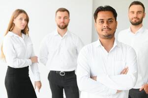 Happy businesspeople laughing while collaborating on a new project in an office. Group of diverse businesspeople working together in a modern workspace photo