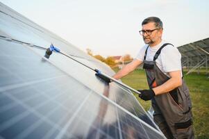 A handyman cleaning solar panels photo