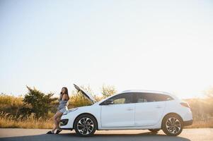 triste mujer Deprimido no conocimiento qué a hacer con roto coche foto