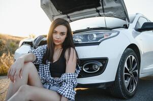 triste mujer Deprimido no conocimiento qué a hacer con roto coche foto