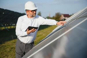 trabajador pruebas solar paneles con tableta. foto