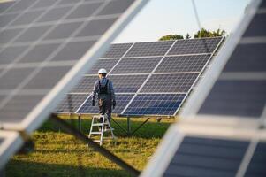 un indio masculino trabajador es trabajando en instalando solar paneles en un campo foto