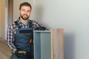 Professional Furniture Assembly Worker Assembles Shelf. Professional Handyman Doing Assembly Job Well photo