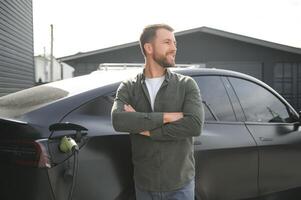 a man charges an electric car photo