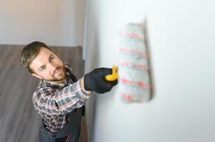 painter man painting the wall, with paint roller photo