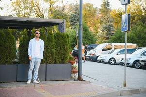 Blinded man waiting for bus at a bus station photo