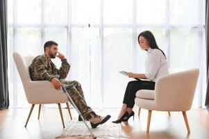 Sad male soldier on appointment with psychologist at office photo