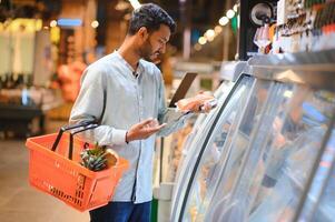 retrato de indio masculino en tienda de comestibles con positivo actitud foto