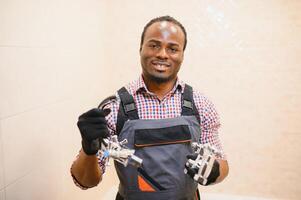 African american plumber holding faucet photo