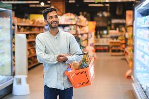 retrato de indio masculino en tienda de comestibles con positivo actitud foto