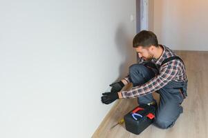 Electrician installs decorative frame on electric and TV sockets photo