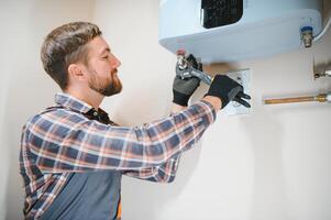 Professional engineer installing a natural gas boiler at home, he is checking the pipes photo