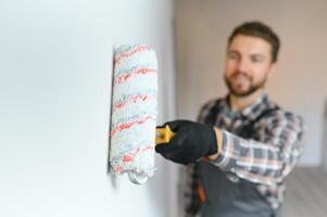 painter man painting the wall, with paint roller photo