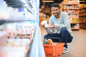 retrato de contento hermoso joven indio a tienda de comestibles tienda o supermercado. foto