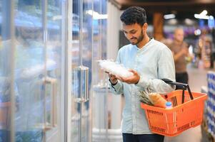 retrato de contento hermoso joven indio a tienda de comestibles tienda o supermercado. foto