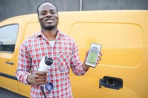 African american man charging car at vehicle charging station photo