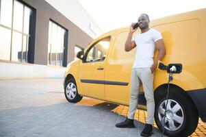 African American man charging his electric car. photo