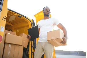 mensajero servicio. entrega hombre con cajas cerca coche foto