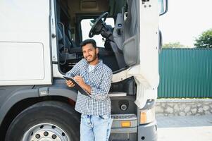 Portrait of confident indian truck driver on parking. Copy space. photo