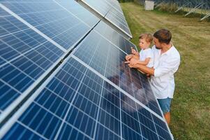 Father and his little son near solar panels. photo