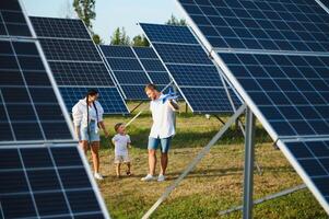 contento familia cerca solar paneles alternativa energía fuente foto